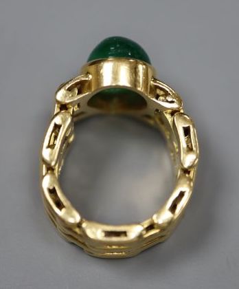 A yellow metal and solitaire pear shaped cabochon emerald set ring, with articulated shank, size G/H, gross 9 grams,